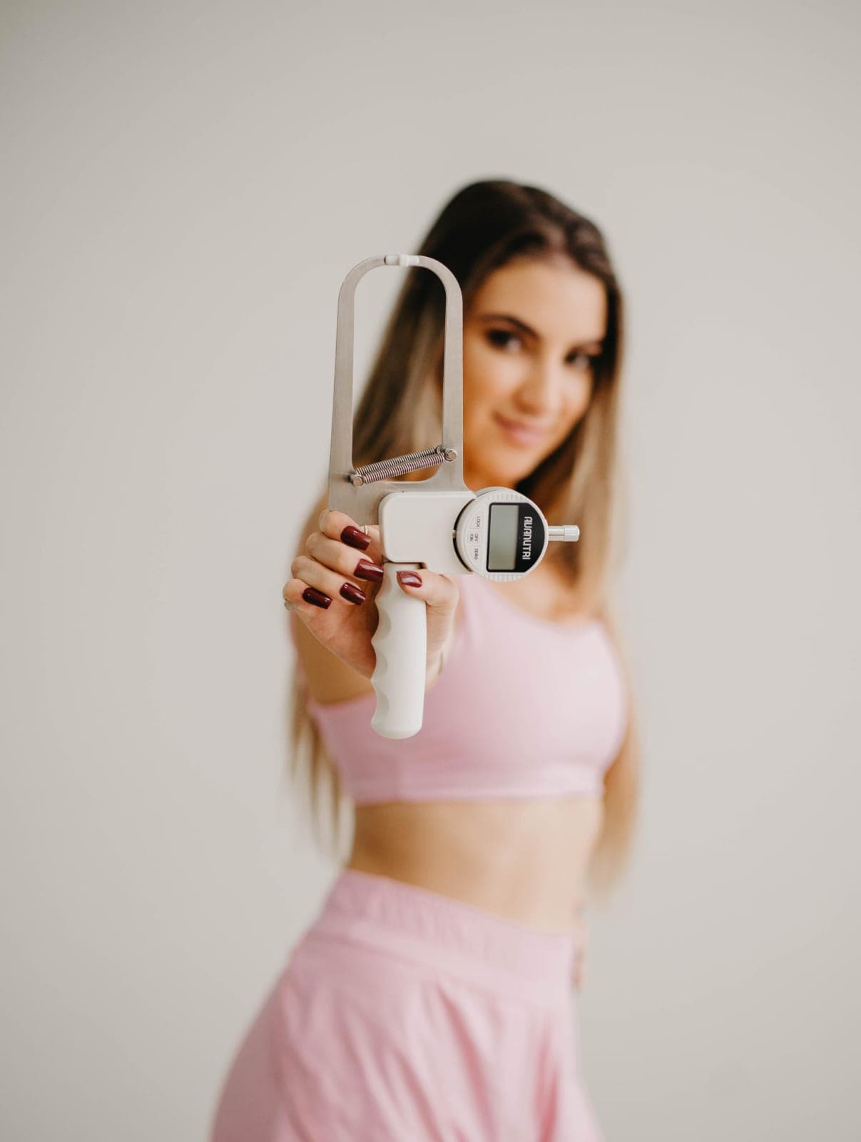 Patrícia apresentando o adipômetro durante avaliação física