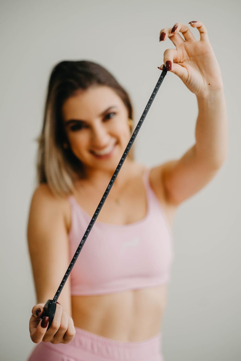 Patrícia utilizando fita métrica na avaliação corporal